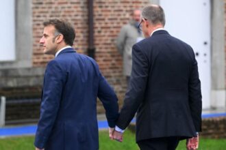 emmanuel macron si friedrich merz aparitie neasteptata la summitul informal unitate afisata in ciuda tensiunilor economice cei doi s au tinut strans de mana 698e323717161